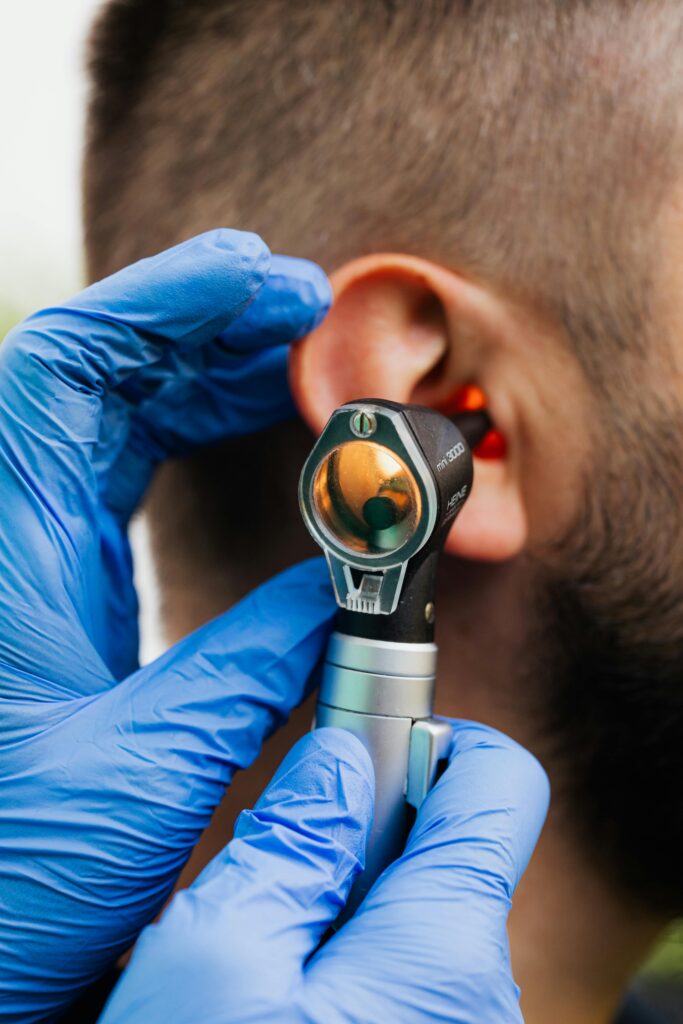 Close-up of a doctor using an otoscope to examine a patient